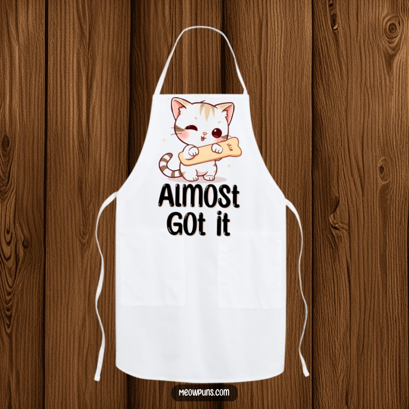 Funny apron featuring a cute cat character intensely focused on snagging a floating fishbone, ready for kitchen adventures and culinary mishaps.