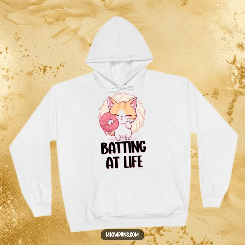 Funny hoodie featuring a playful cat batting a giant, fuzzy yarn pom-pom, perfect for cozying up with humorous charm.