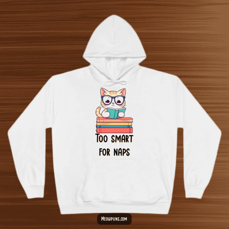 Funny hoodie showcasing a wise cat wearing reading glasses, sitting atop a pile of books, radiating intellect and comfort.