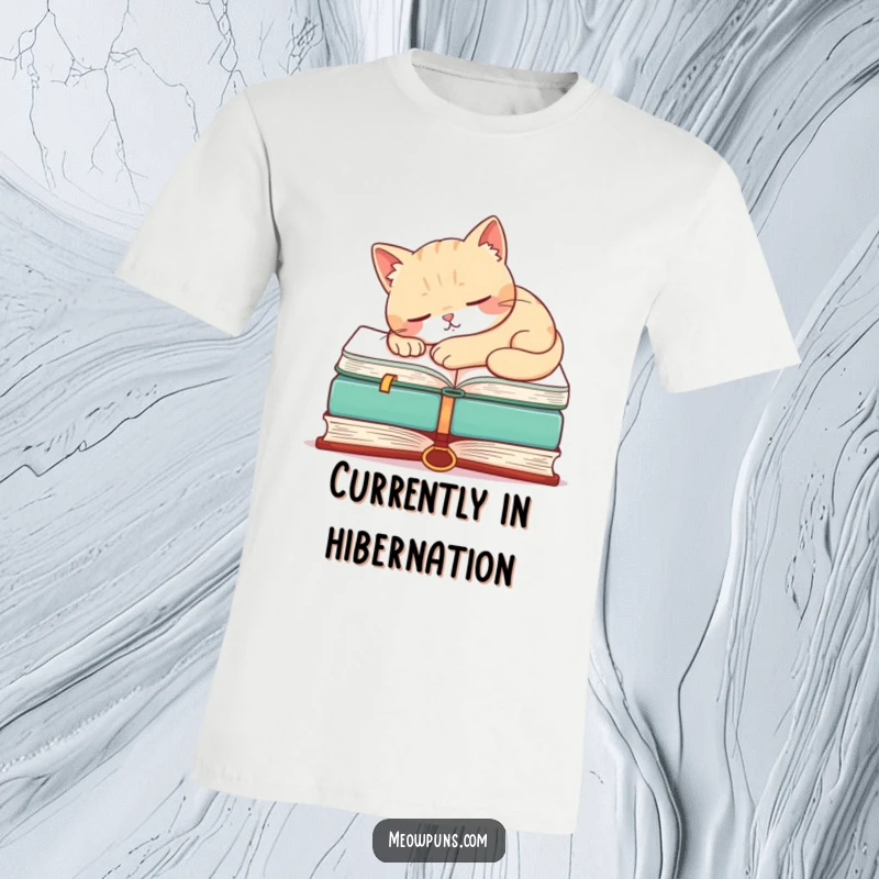 Funny t-shirt with a sleeping cat resting on a massive book, showcasing a humorous and relaxing vibe.