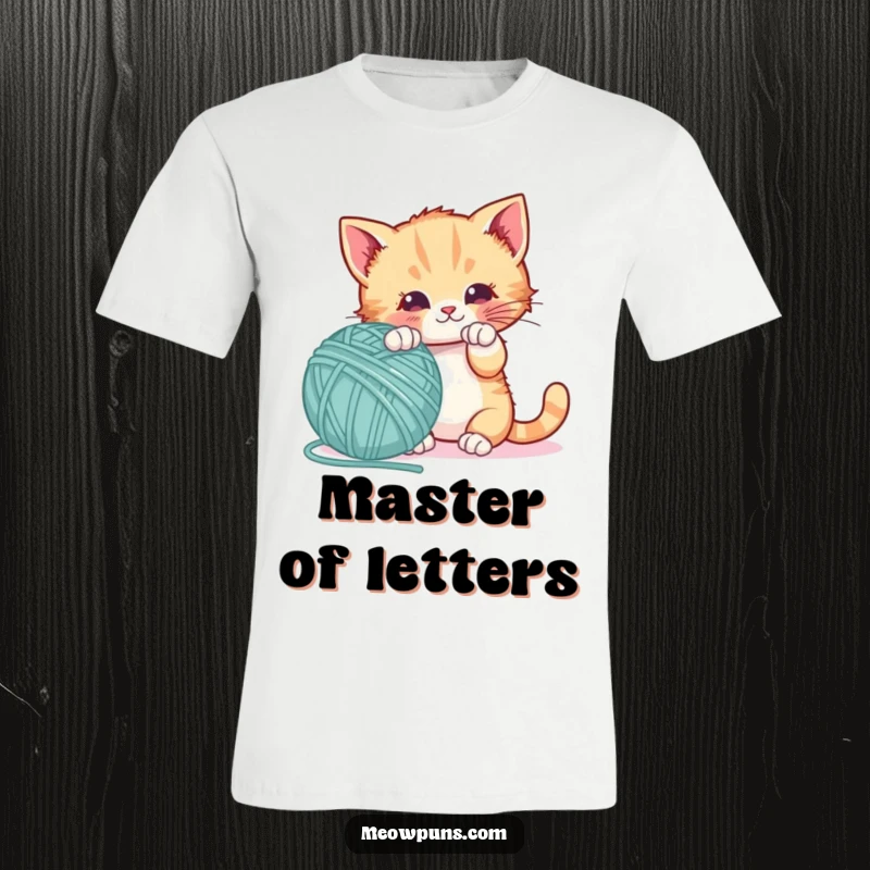 Funny t-shirt with a playful kitten batting a giant letter-shaped yarn ball, radiating joy and a love for play.
